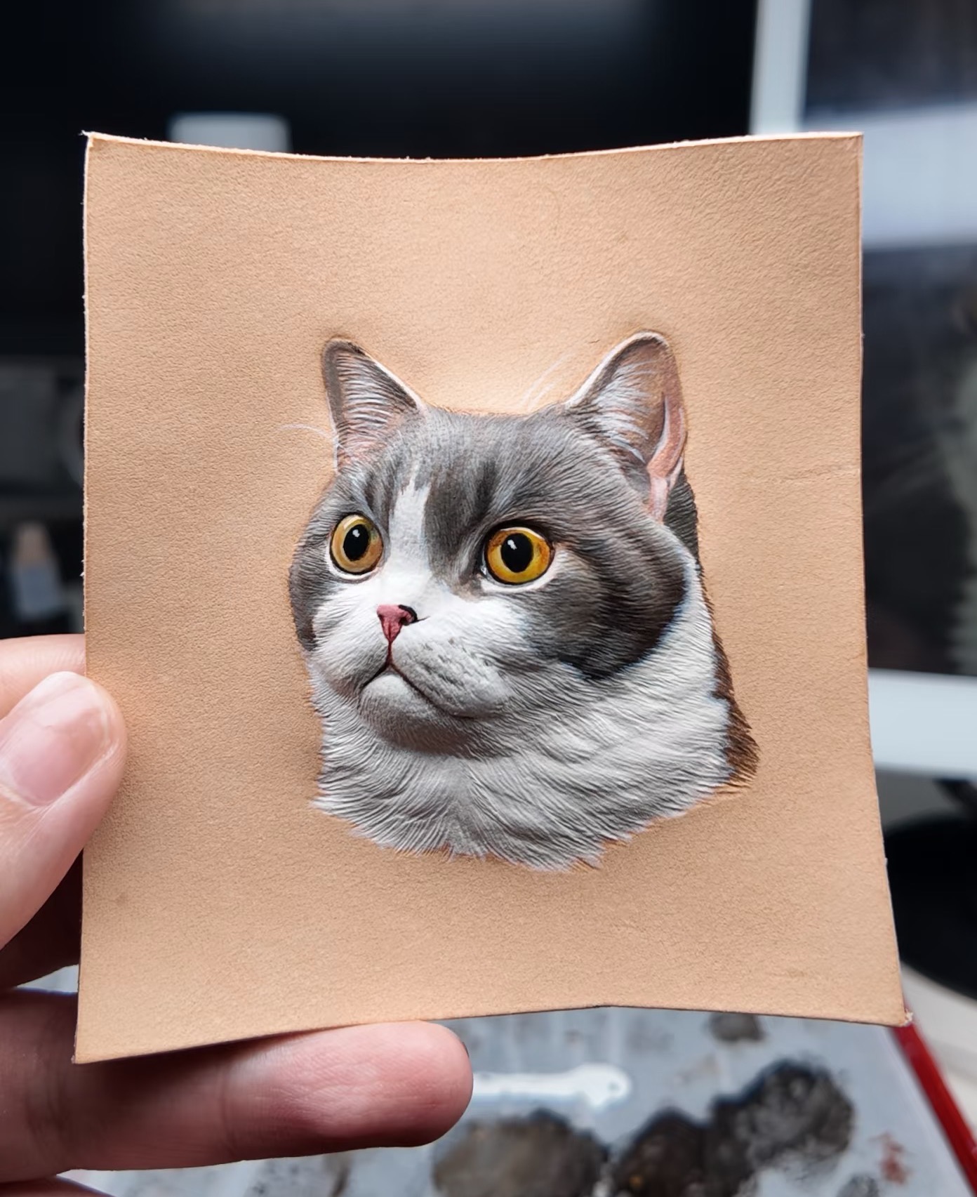 Hand carved leather pet portrait on workbench